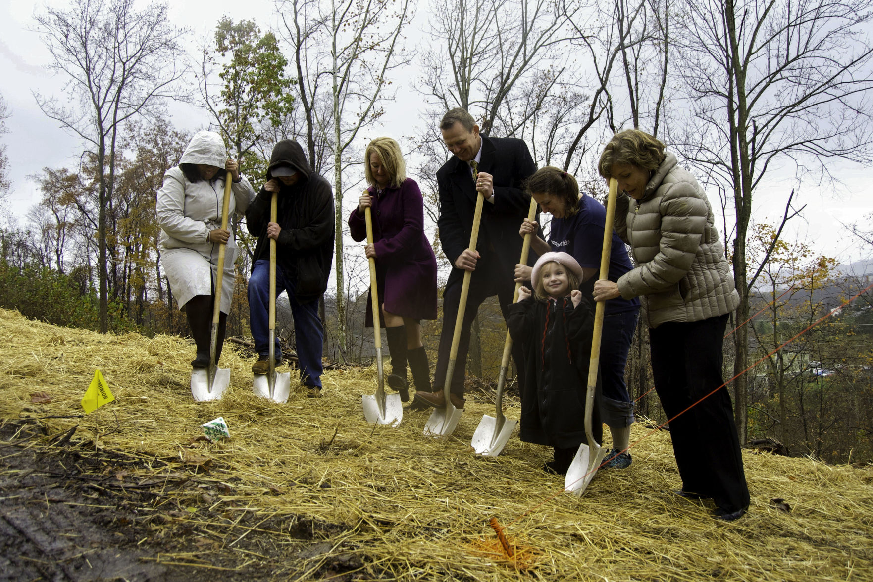 Members of WVU Athletics, Mon Valley Habitat for Humanity and families that will benefit from the project break ground at the new site.